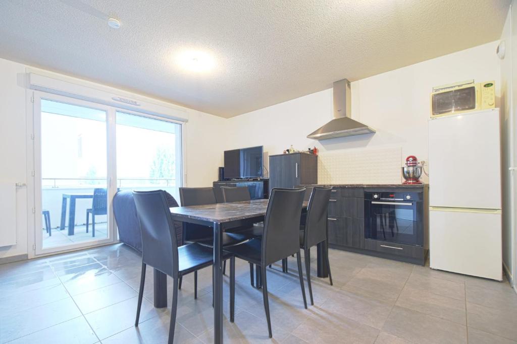 a kitchen with a table and chairs and a refrigerator at Beautiful Bright Apt With Terrace in Lyon