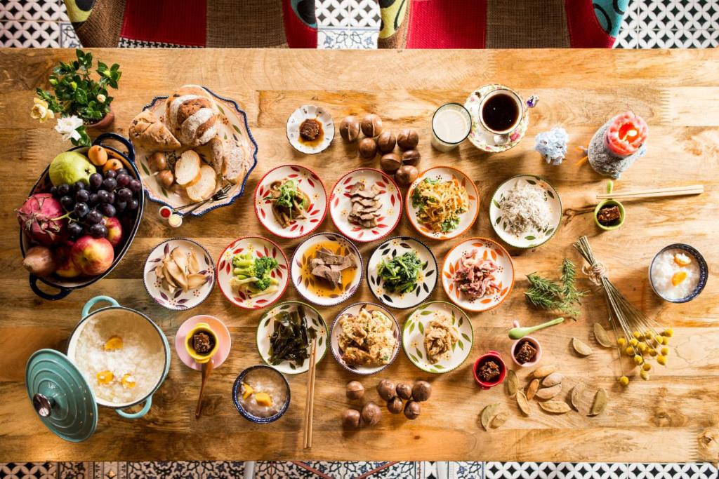 a wooden table with plates of food on it at Happiness B&amp;B in Luodong
