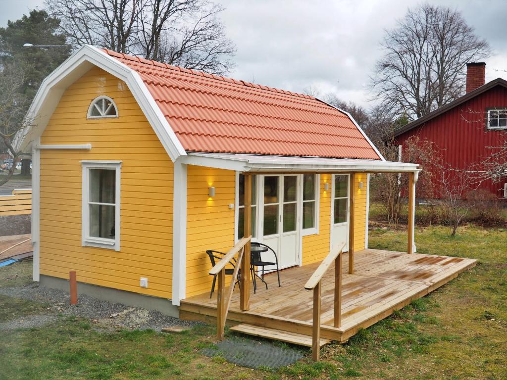 una casa gialla con tetto arancione e terrazza di Kristina Attefall i Västerhaninge a Västerhaninge