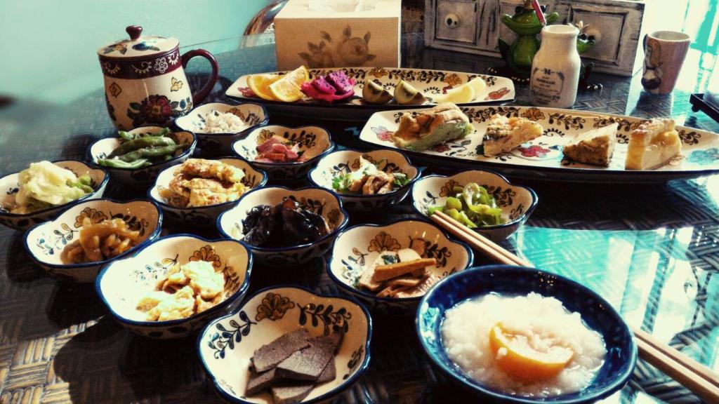 a table with many dishes of food on it at Happiness B&amp;B in Luodong