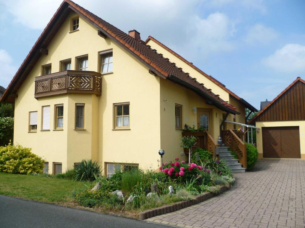 een geel huis met een bruin dak bij Ferienwohnungen Dippold in Scheßlitz