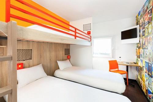 a bedroom with two beds and a desk and a bunk bed at hotelF1 Compiègne in Venette