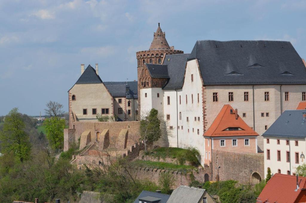 een groot kasteel op een heuvel met gebouwen bij Kleiner-Burgblick in Leisnig