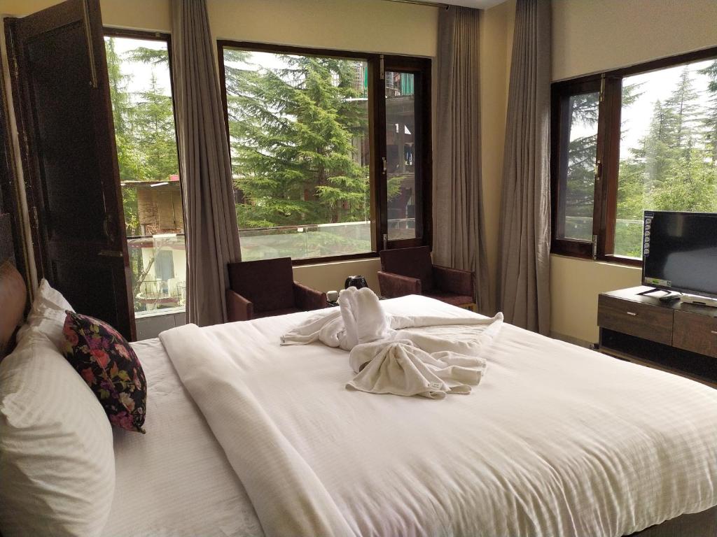 A bed or beds in a room at Golden Rock, Dharamshala - AM Hotel Kollection