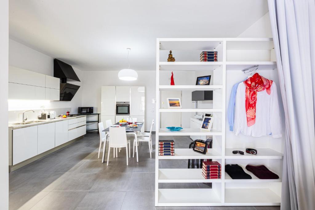 a kitchen and dining room with white cabinets at Conny's House in Sorrento