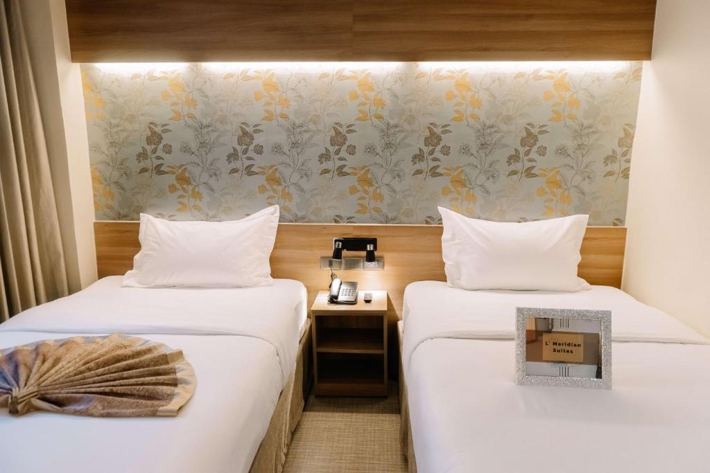 Postel nebo postele na pokoji v ubytování L' Meridian Suites