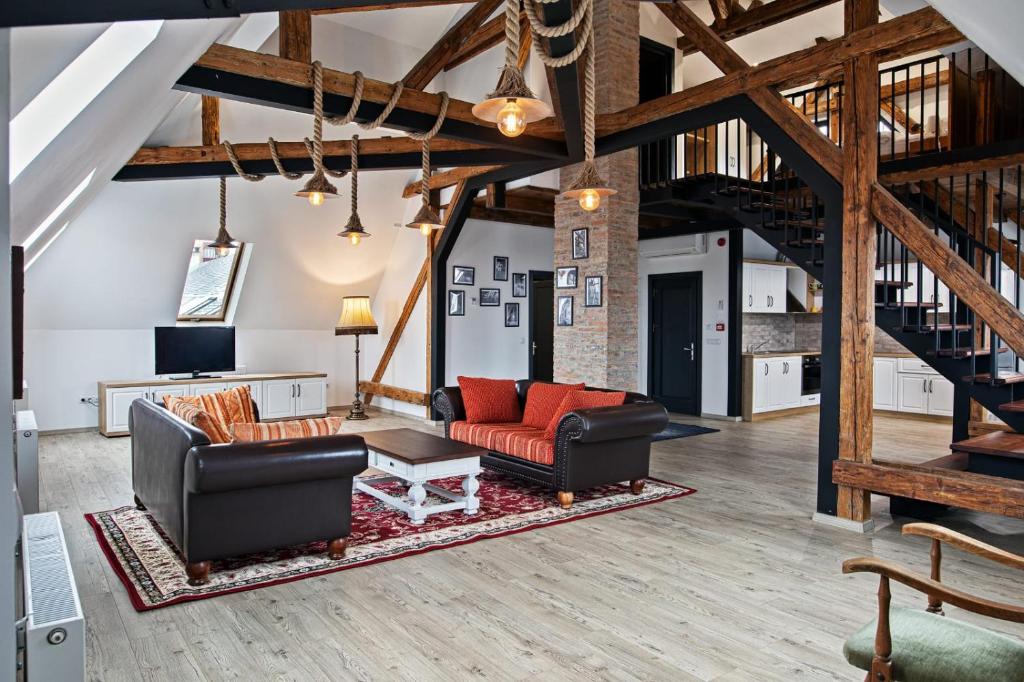 a living room with two couches and a table at The Bricks 1903 Lofts - Central Bistrita in Bistriţa
