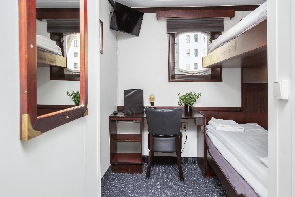 a small room with a desk and a bed and bunk beds at Mälardrottningen Yacht Hotel in Stockholm