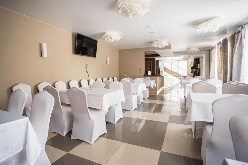 ノヴォシビルスクにあるPrimorye Hotelの白いテーブルと白い椅子が備わるお部屋