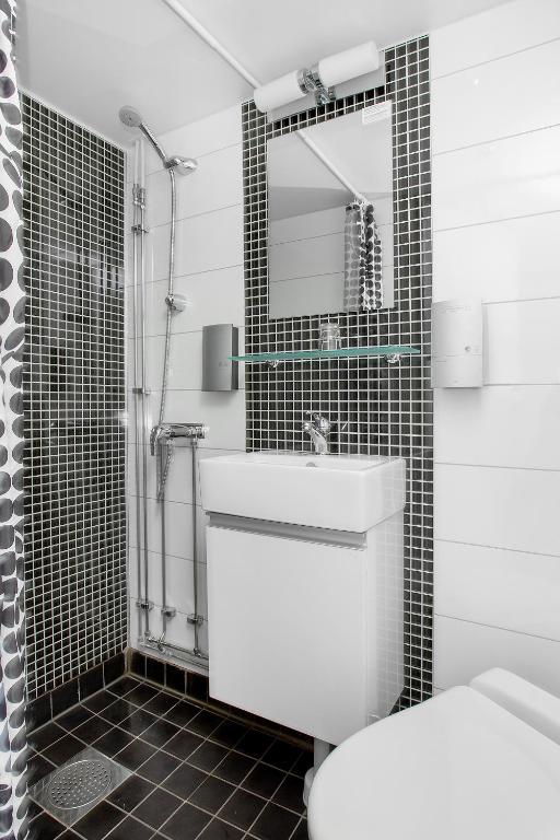 a bathroom with a toilet and a sink and a mirror at Mälardrottningen Yacht Hotel in Stockholm