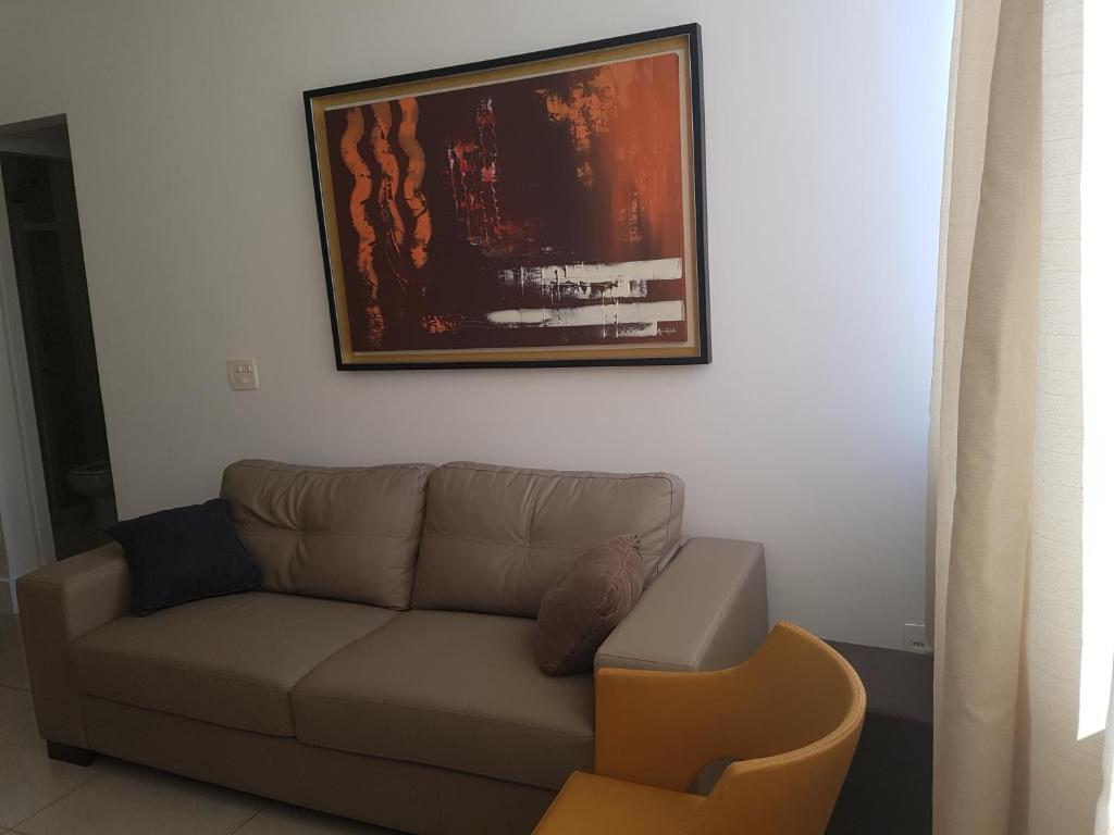 sala de estar con sofá y una foto en la pared en Apartamento Ed Cadima, en Río de Janeiro