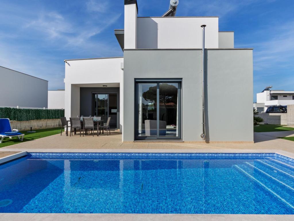 a swimming pool in front of a villa at Luxury villa with private heated pool in Foz do Arelho