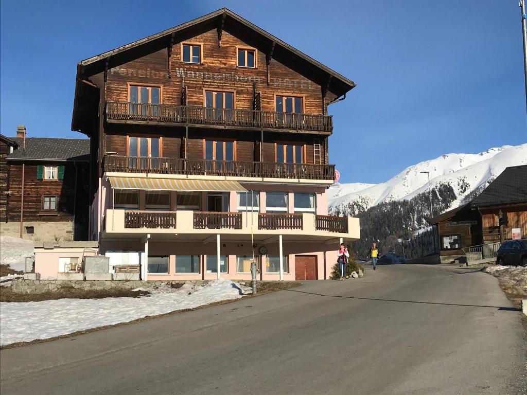 ein großes Holzgebäude an der Seite einer Straße in der Unterkunft Hotel Wannenhorn in Bellwald