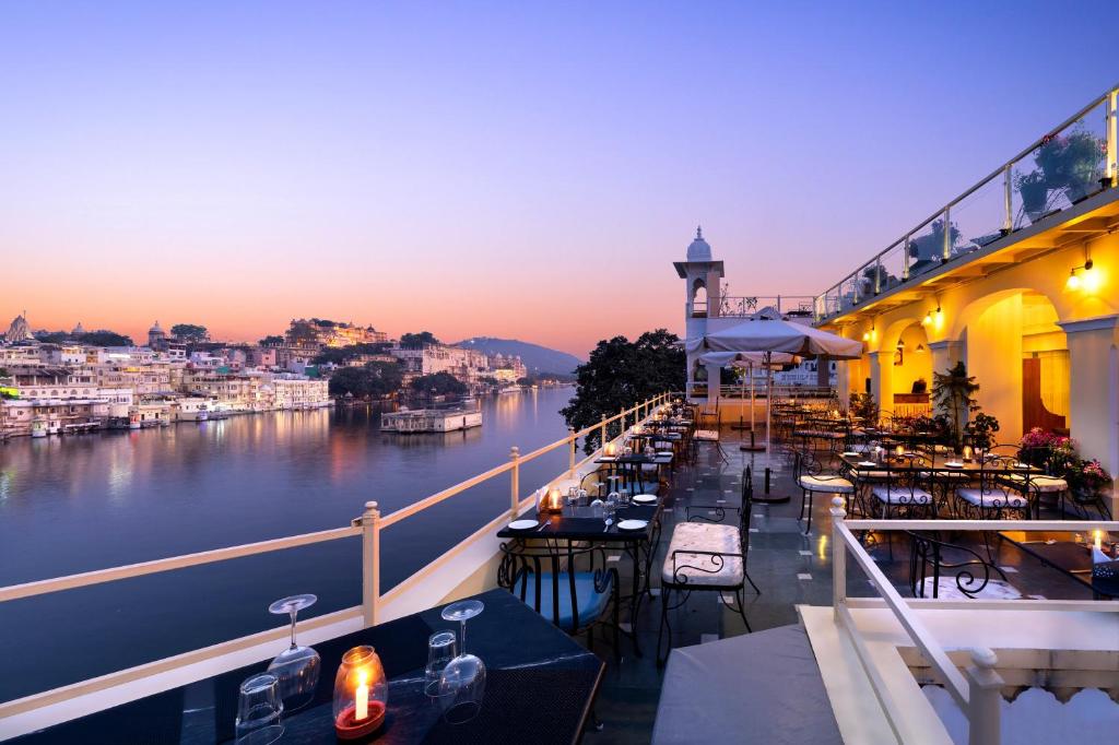a balcony of a restaurant with a view of a river at Hotel Sarovar On Lake Pichola in Udaipur
