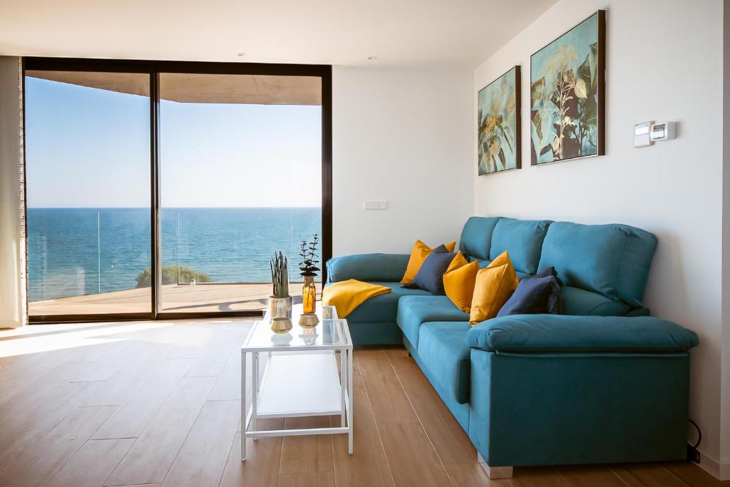 a blue couch in a living room with a table at Modern sea front Reef in Alicante