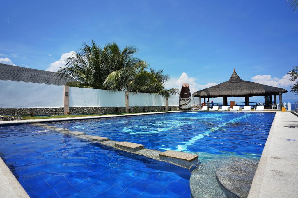 a large blue swimming pool with a gazebo at Club Hari Dive Resort in Moalboal