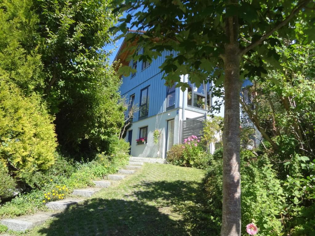 a blue building with a tree in front of it at Ferienwohnung Eisele in Buchenberg