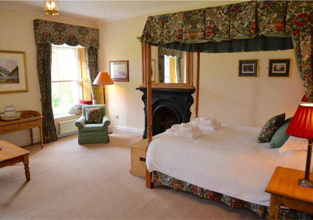 a bedroom with a large bed and a fireplace at Delphi Lodge in Leenaun
