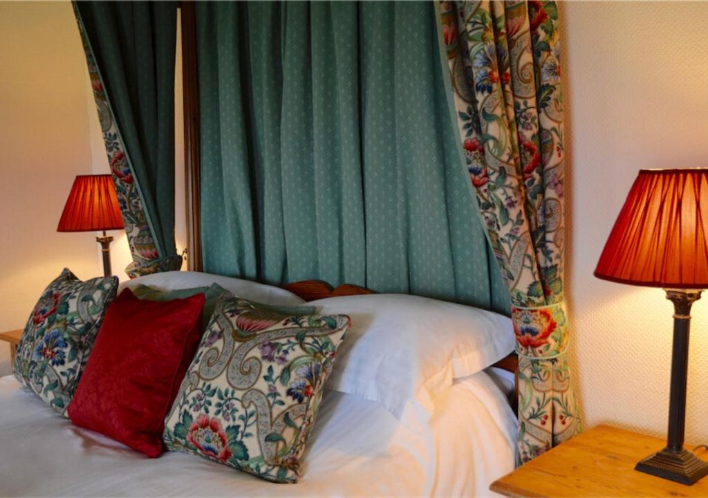 a bedroom with a bed with a canopy and two lamps at Delphi Lodge in Leenaun