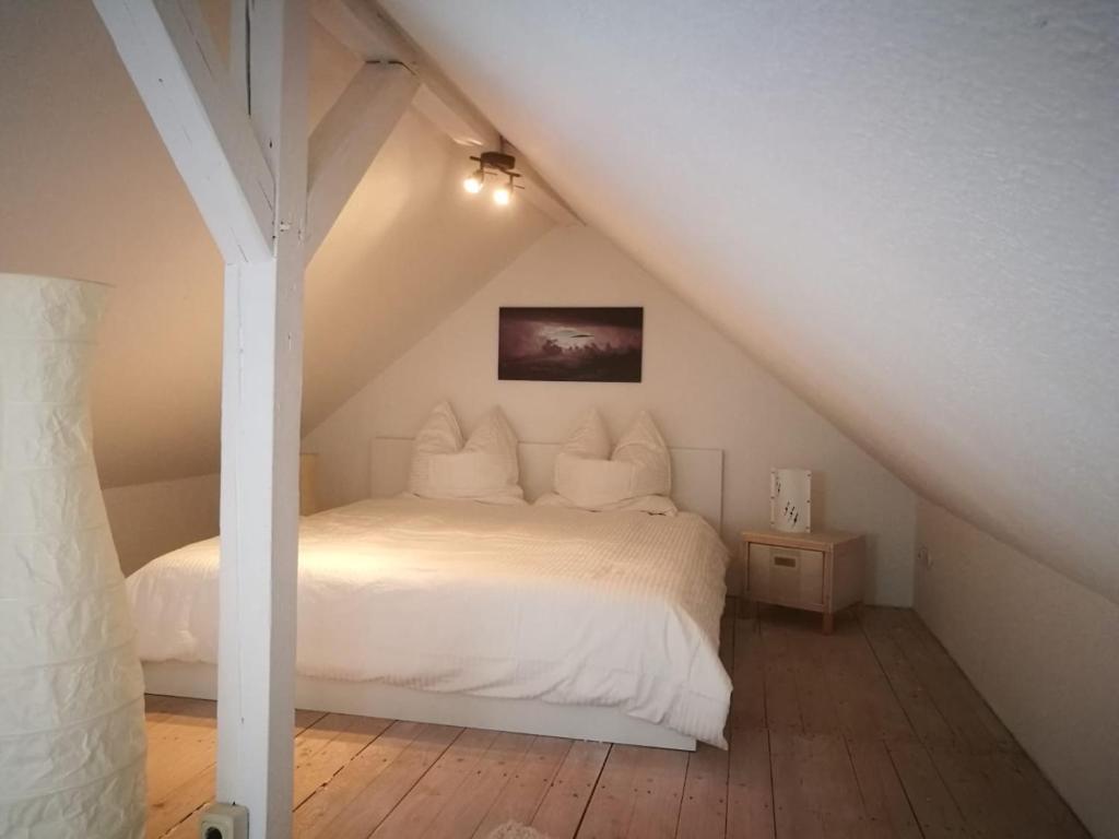 1 dormitorio con 1 cama blanca en el ático en 45 m² Maisonette-Wohnung in Uni-/Hauptbahnhofnähe, en Duisburg