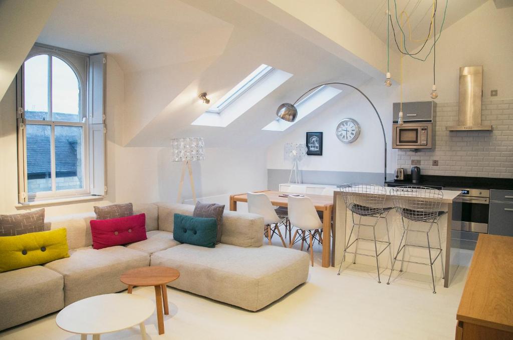 uma sala de estar e cozinha com um sofá e uma mesa em Regent House deluxe 1 bedroom apartment em Harrogate