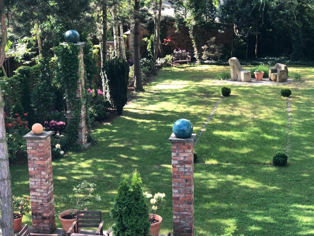 een tuin met een gazon met planten en bomen bij Pension Bloo Tomato in Zittau