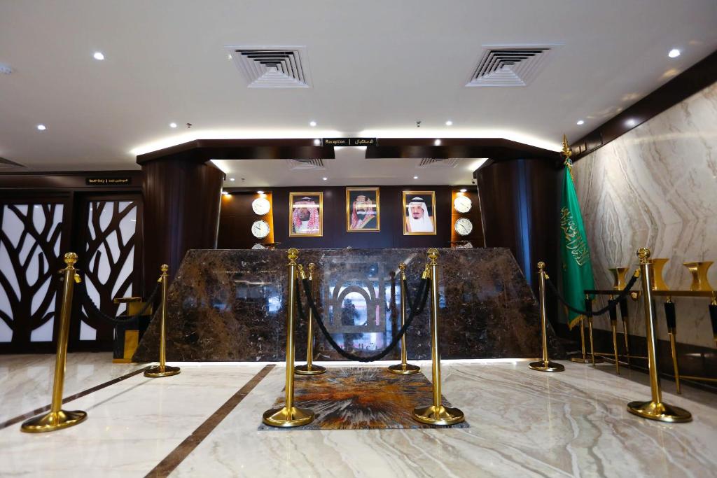 a room with a stage with gold posts and pictures at Bait Aldiyafah Hotel Apartments in Jeddah