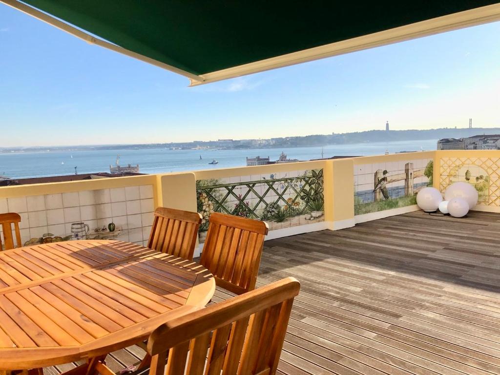 einen Tisch und Stühle auf einer Terrasse mit Meerblick in der Unterkunft Terraço do Tejo in Lissabon