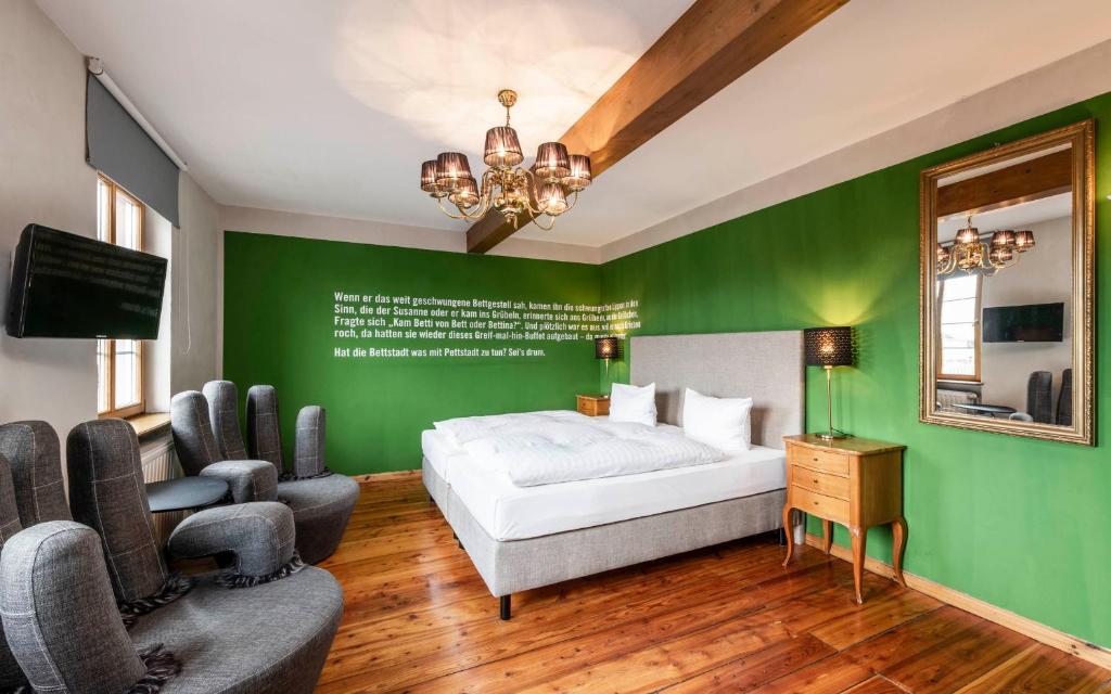 a bedroom with a bed and a green wall at Hotel Turmdieb in Volkach