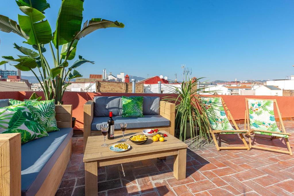 patio con divano e tavolo sul tetto di Glam Penthouse Barcelona a Barcellona