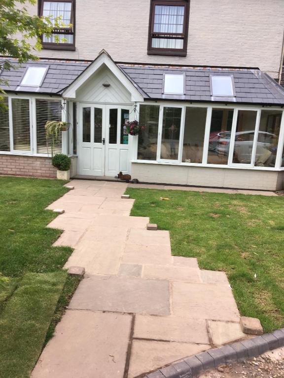 a house with a stone walkway in front of a house at Henwick house accommodation in Ludlow