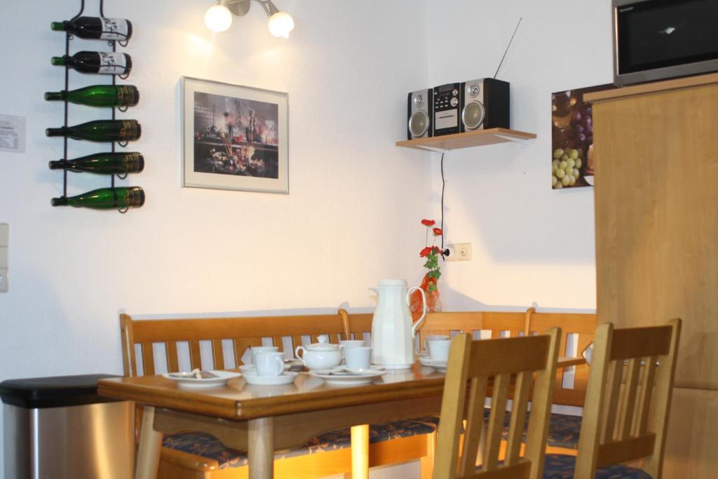 uma mesa de jantar e cadeiras com garrafas de vinho na parede em Komfort Ferienhaus FEWO70 em Bremm