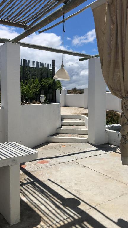 a patio with a bench and a fence at Pearly Beach greek style retreat in Pearly Beach
