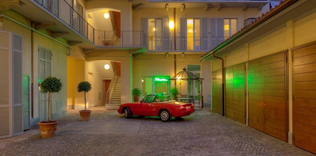 Santa Giulia Hotel e Residence Torino في تورينو: سيارة حمراء متوقفة في موقف للسيارات في مبنى