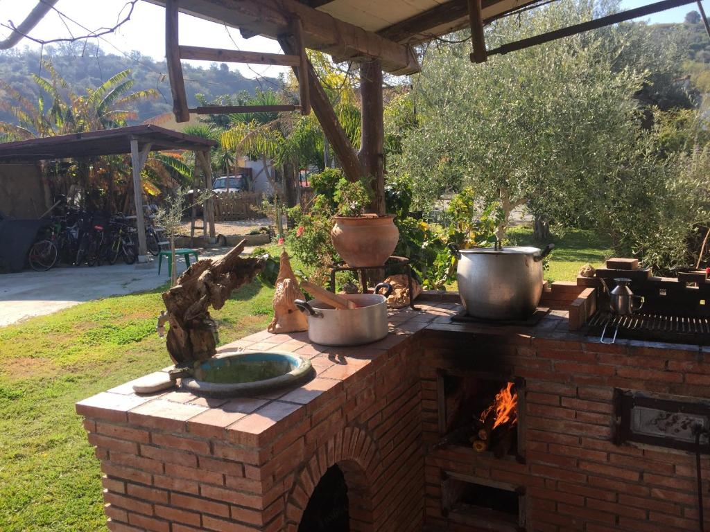 un horno de ladrillo con ollas y sartenes encima en Casa Vacanze Borgo Borghese, en SantʼAlessio Siculo