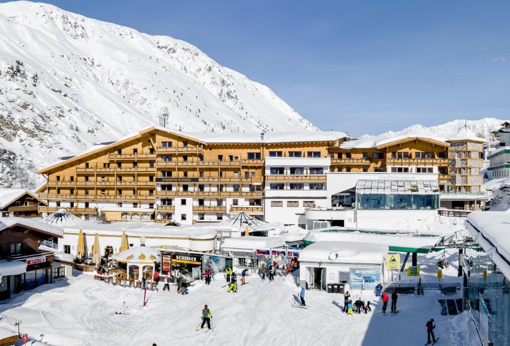 a group of people skiing in the snow in front of a hotel at Hotel Edelweiss & Gurgl in Obergurgl
