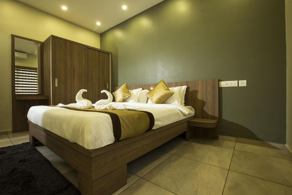 een slaapkamer met een bed met twee zwanen erop bij sahara suites in Cochin