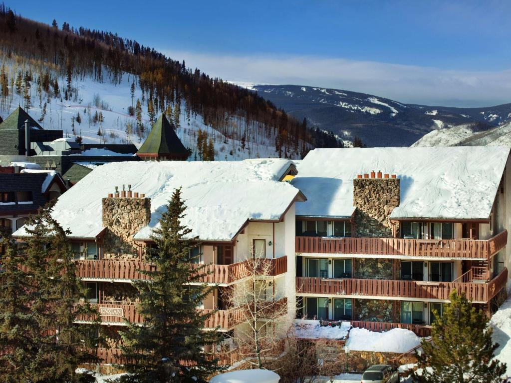 a resort building with snow on the roof at Enzian - CoralTree Residence Collection in Vail