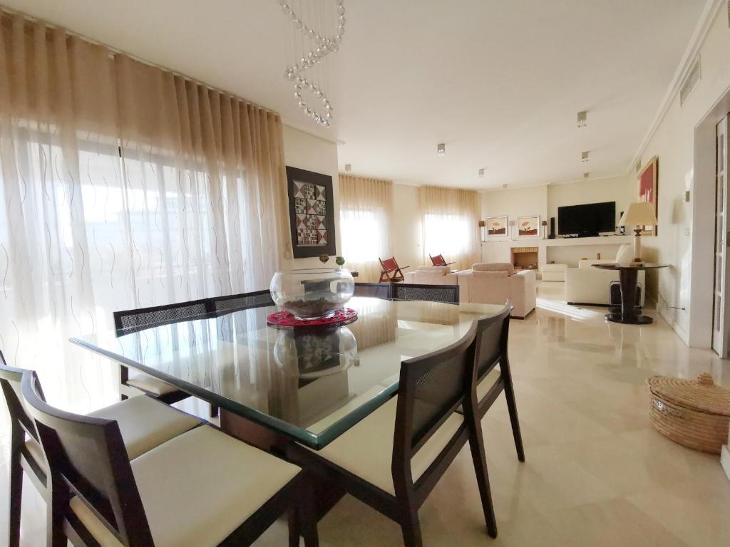 a dining room with a glass table and chairs at Entire floor parque nacoes prime apartments expo30 in Lisbon