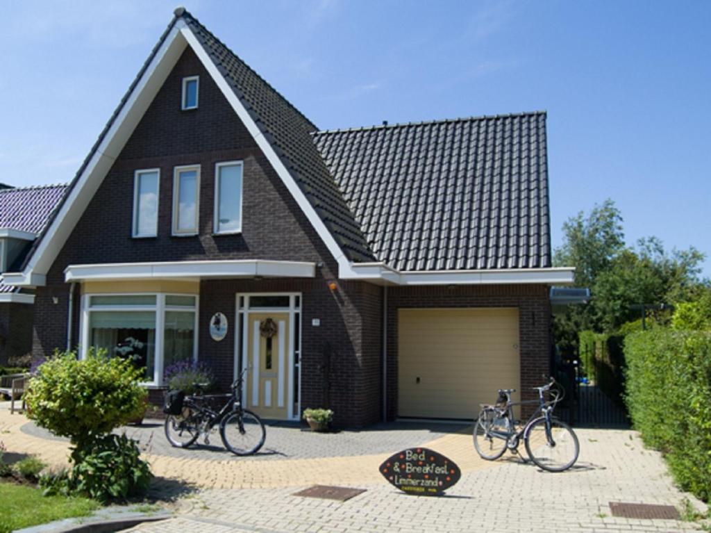 una casa con dos bicicletas estacionadas frente a ella en B&B Limmerzand, en Limmen