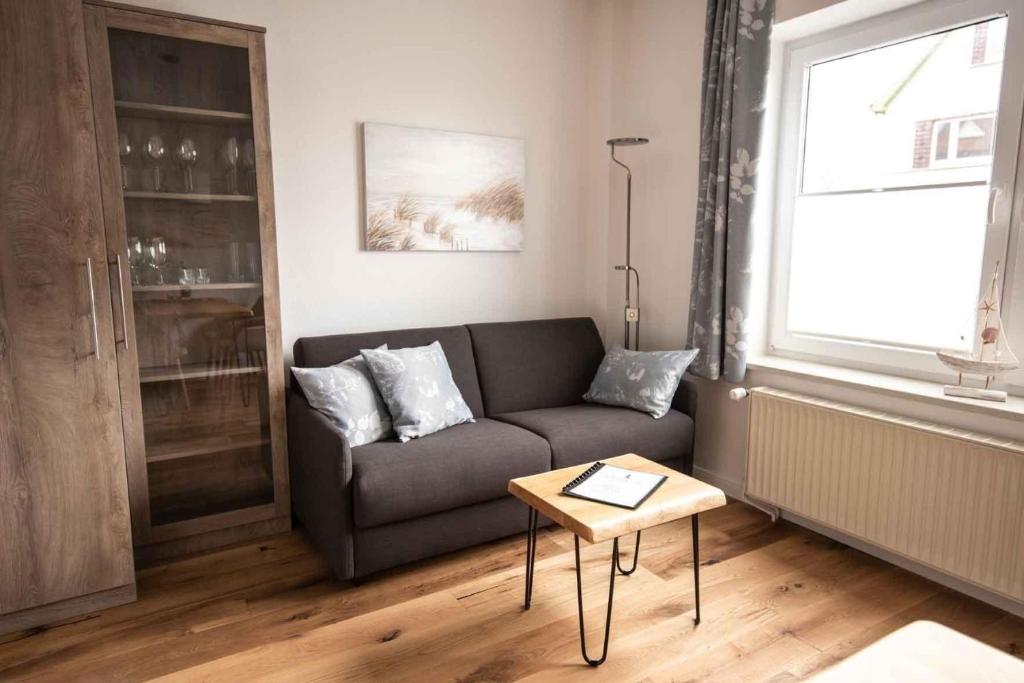 uma sala de estar com um sofá e uma mesa em Ferienwohnung-2-Strandnah-und-mit-Strandkorb-im-Haus-Seeluft-in-Duhnen em Cuxhaven