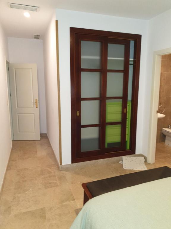 1 dormitorio con puerta de madera y baño en Triana pura esencia, en Sevilla