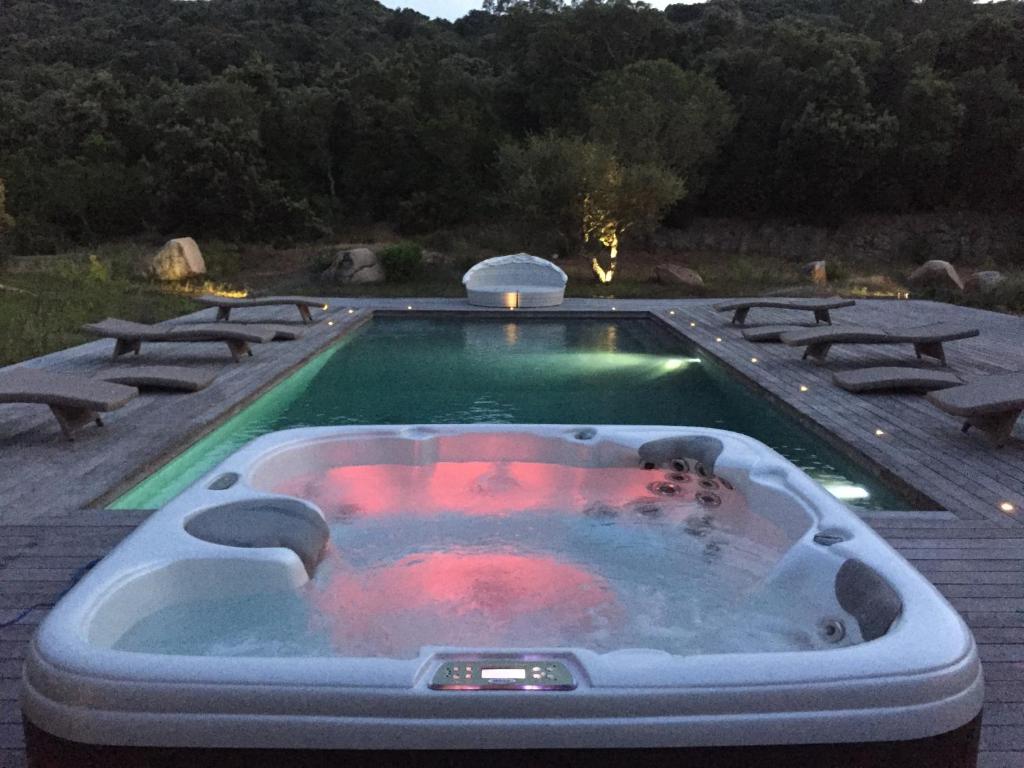 uma pessoa num jacuzzi numa piscina em Villa piscine chauffée 5mn de la plage em Figari