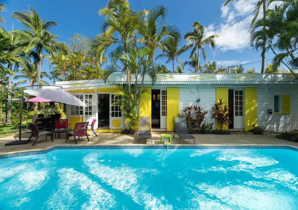 une maison avec une piscine en face d'une maison dans l'établissement Le "bassin pirogues", à L'Étang-Salé