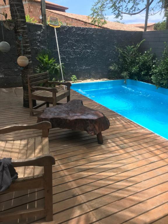 una terraza de madera con un banco junto a la piscina en Casa de ferias, en Trancoso