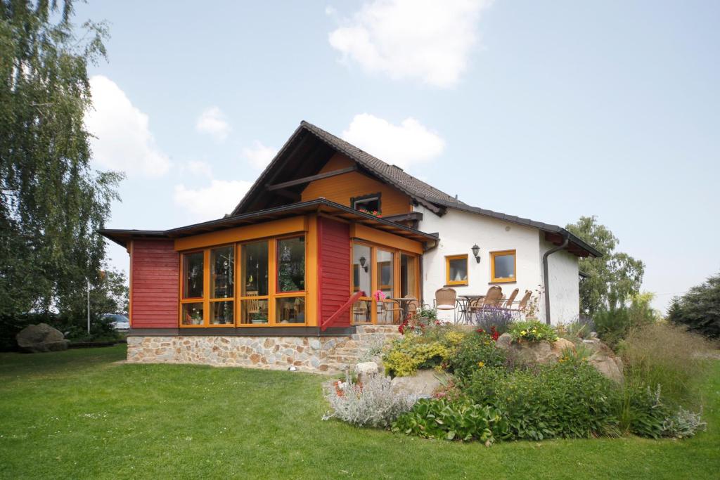 Ce cottage est doté d'une façade rouge et blanche. dans l'établissement Ute's Pension, à Georgenberg