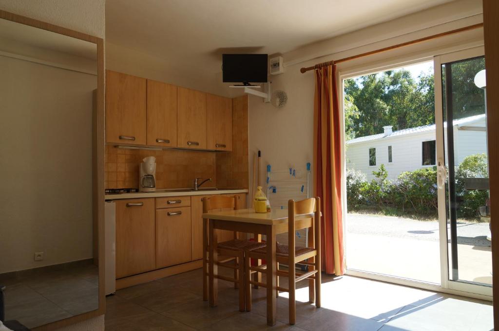 a kitchen with a table and chairs and a window at Résidence Les Castors in Calvi