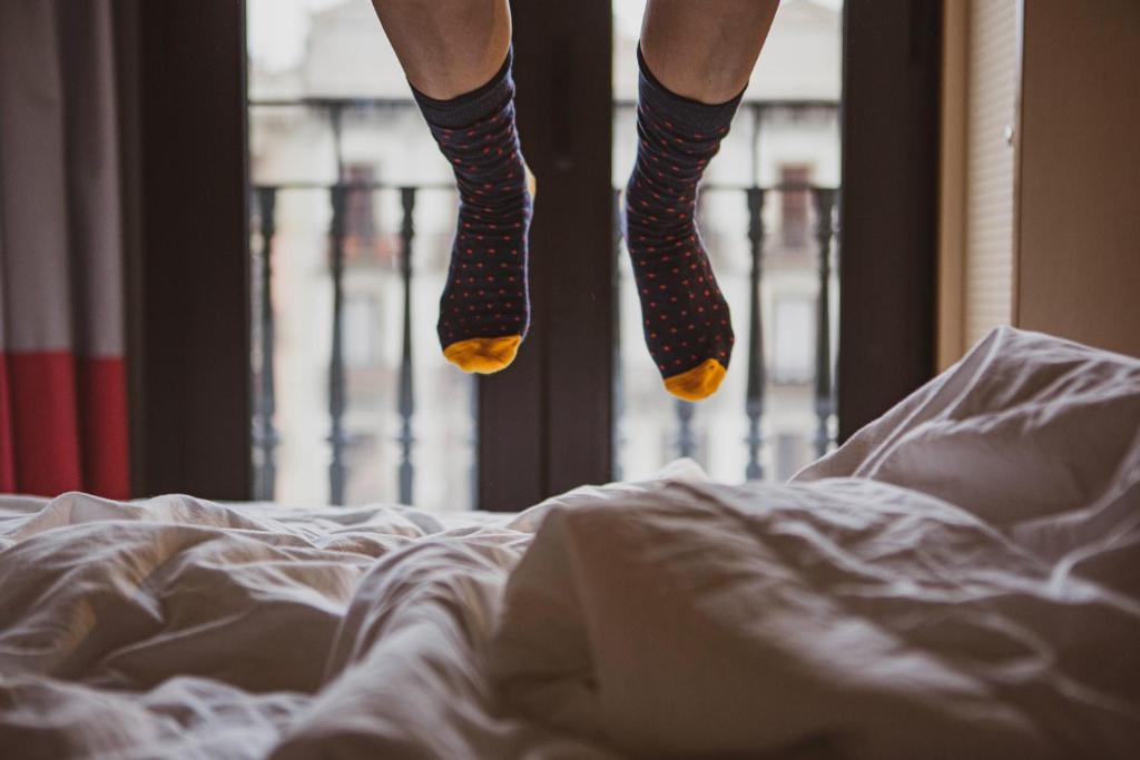 a person in polka dot socks jumping on a bed at TOC Hostel Barcelona in Barcelona