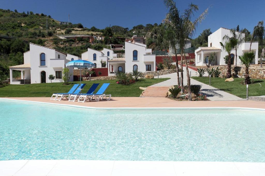 a villa with a swimming pool in front of a house at Cefalù In Casa in Cefalù