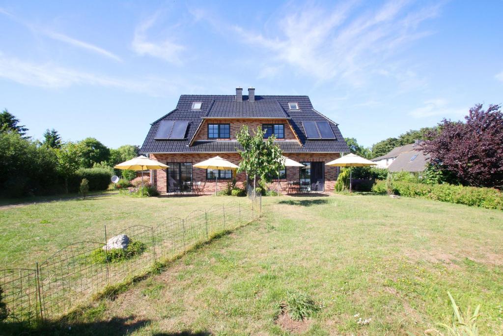 ein großes Haus mit einem Zaun vor einem Hof in der Unterkunft Ostseehaus Odin Doppelhaushälfte in Wiek auf Rügen 